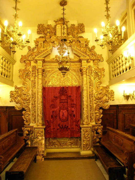 an ornately decorated church alter and two benches