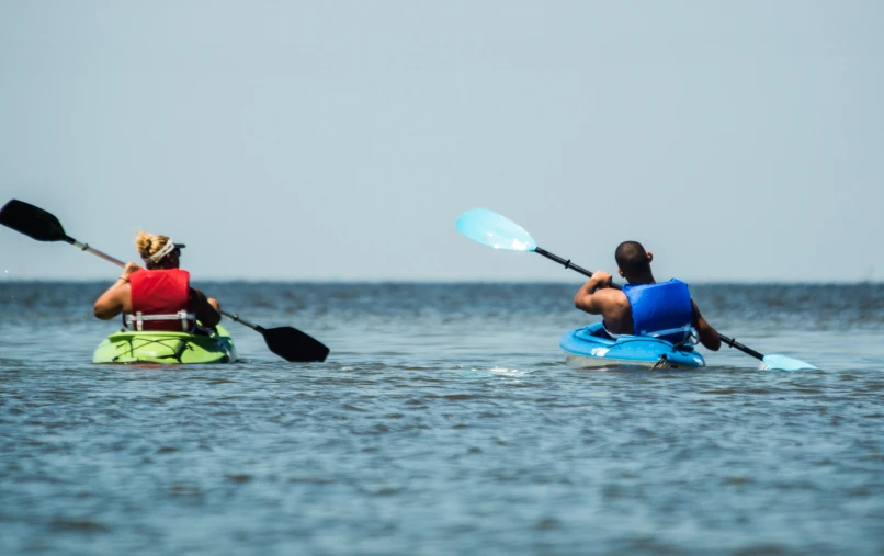 two people are kayaking on the water