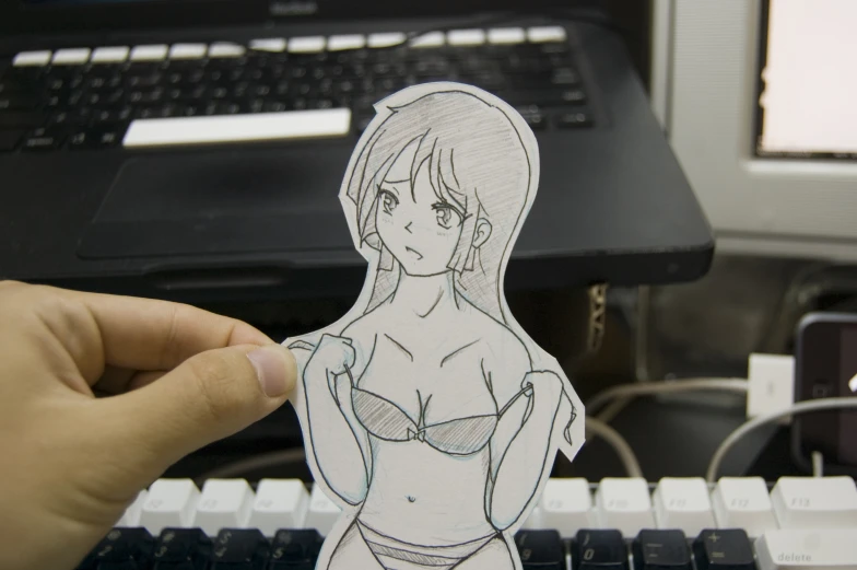 a person holding up a paper cutout of a woman in a bikini
