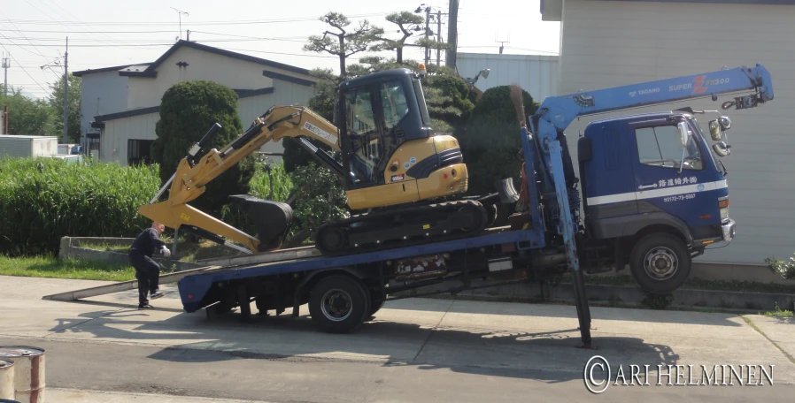 a couple of work vehicles being towed on a tow truck