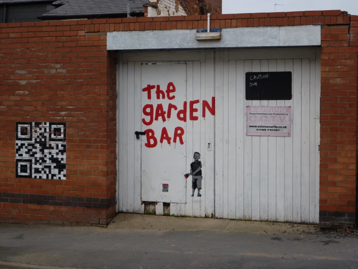 a brick building with grafitti on the doors and a painted door