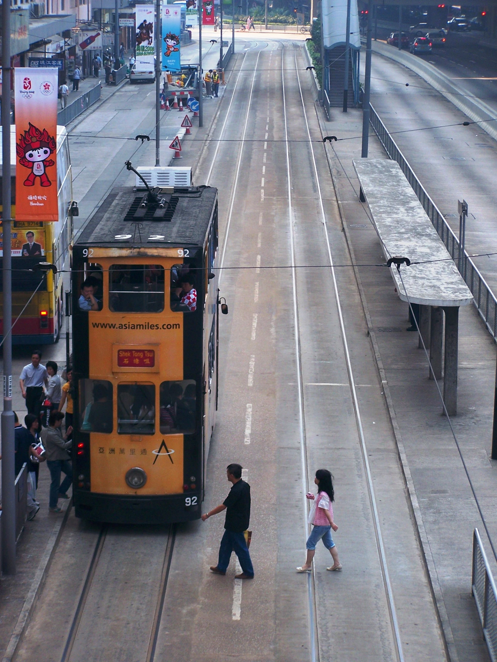 children walk next to an empty bus on a city street