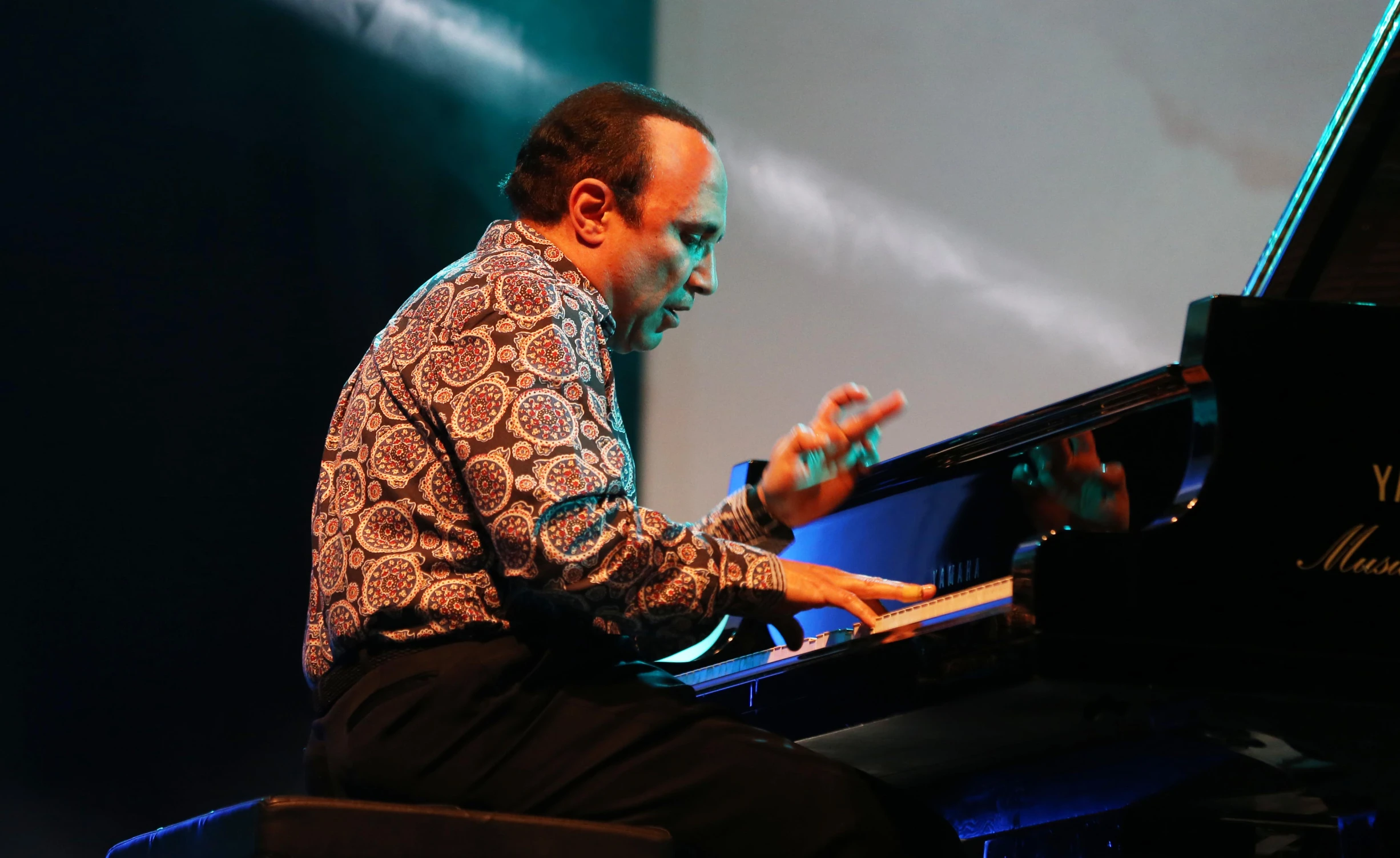 a man playing piano while sitting at a keyboard