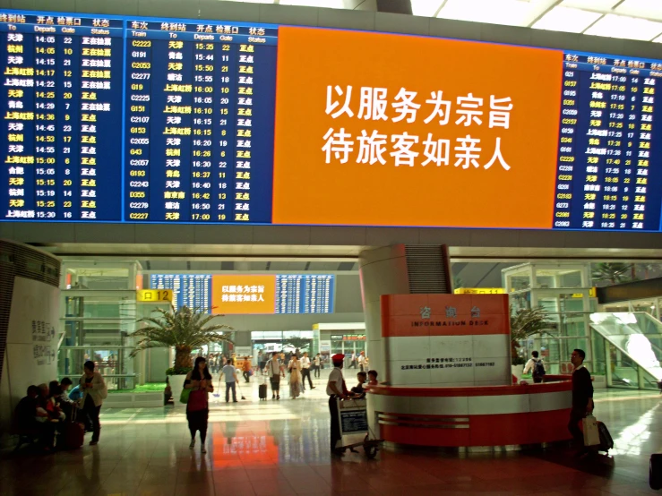 an airport terminal with a large asian clock mounted to the wall