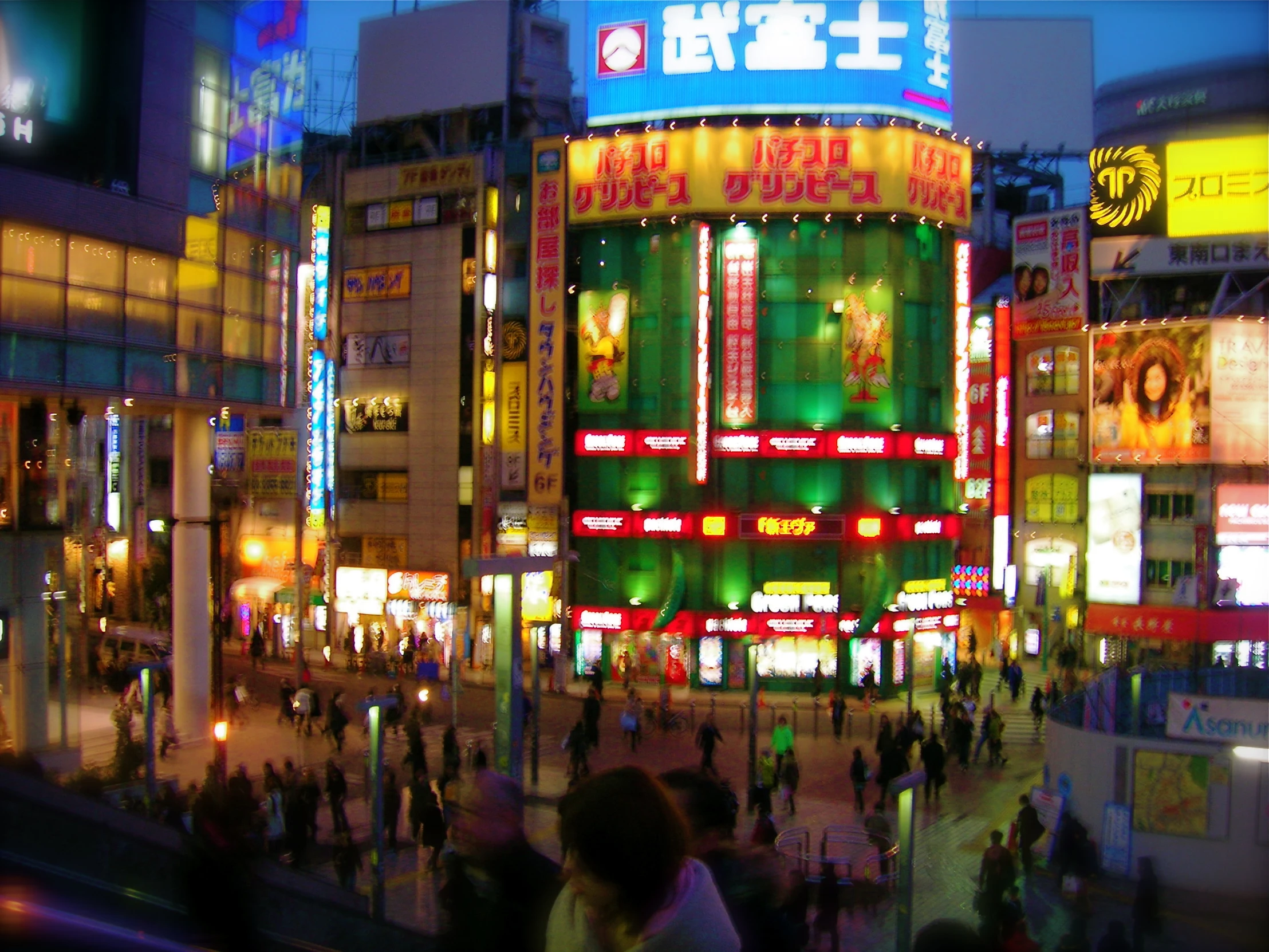 a city street at night with lights of various colors and buildings