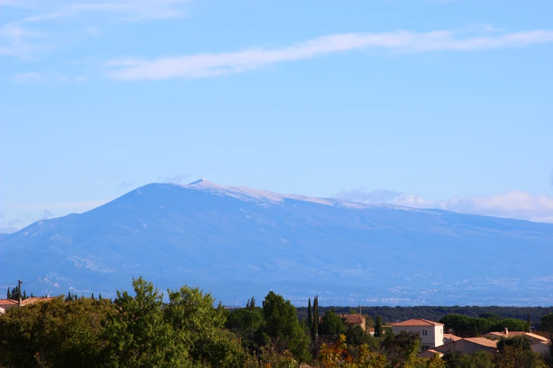 a large mountain sits in the distance behind small houses