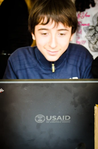 a man looks at a laptop screen while sitting on a chair