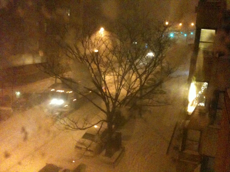 a view of snow covered ground and parked cars