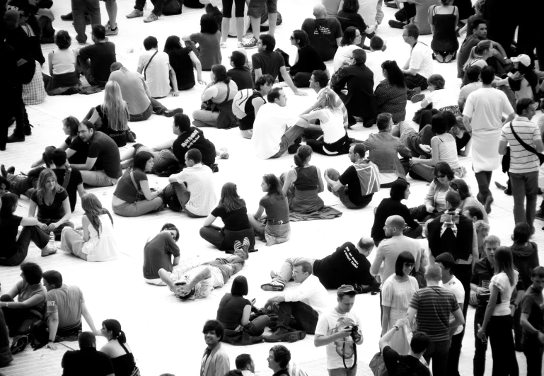 many people sitting on the ground while wearing different kinds of hats