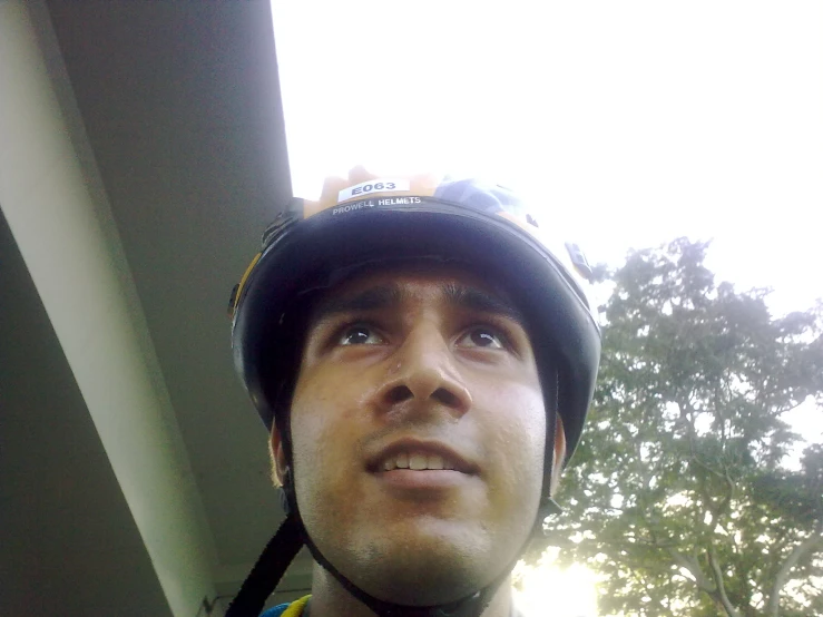 man with a bicycle helmet looks up at the sky