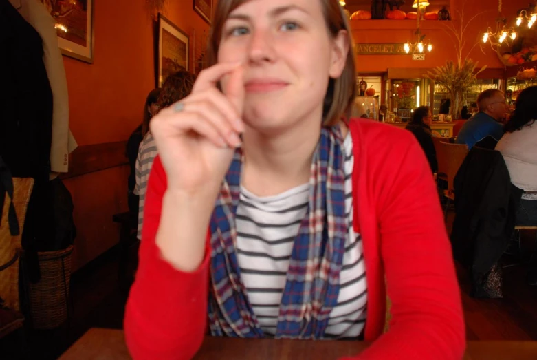 a woman sitting at a table in front of a beer bottle