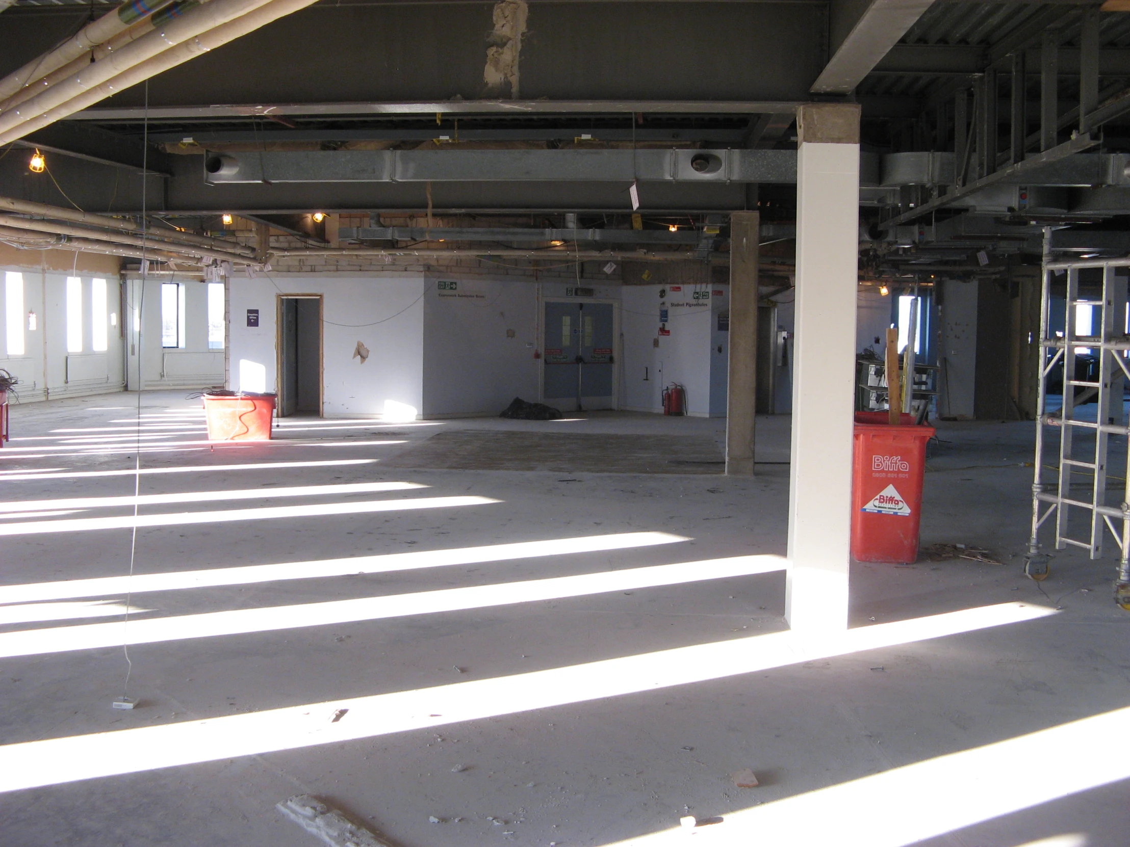 an empty building with white walls and exposed ceiling