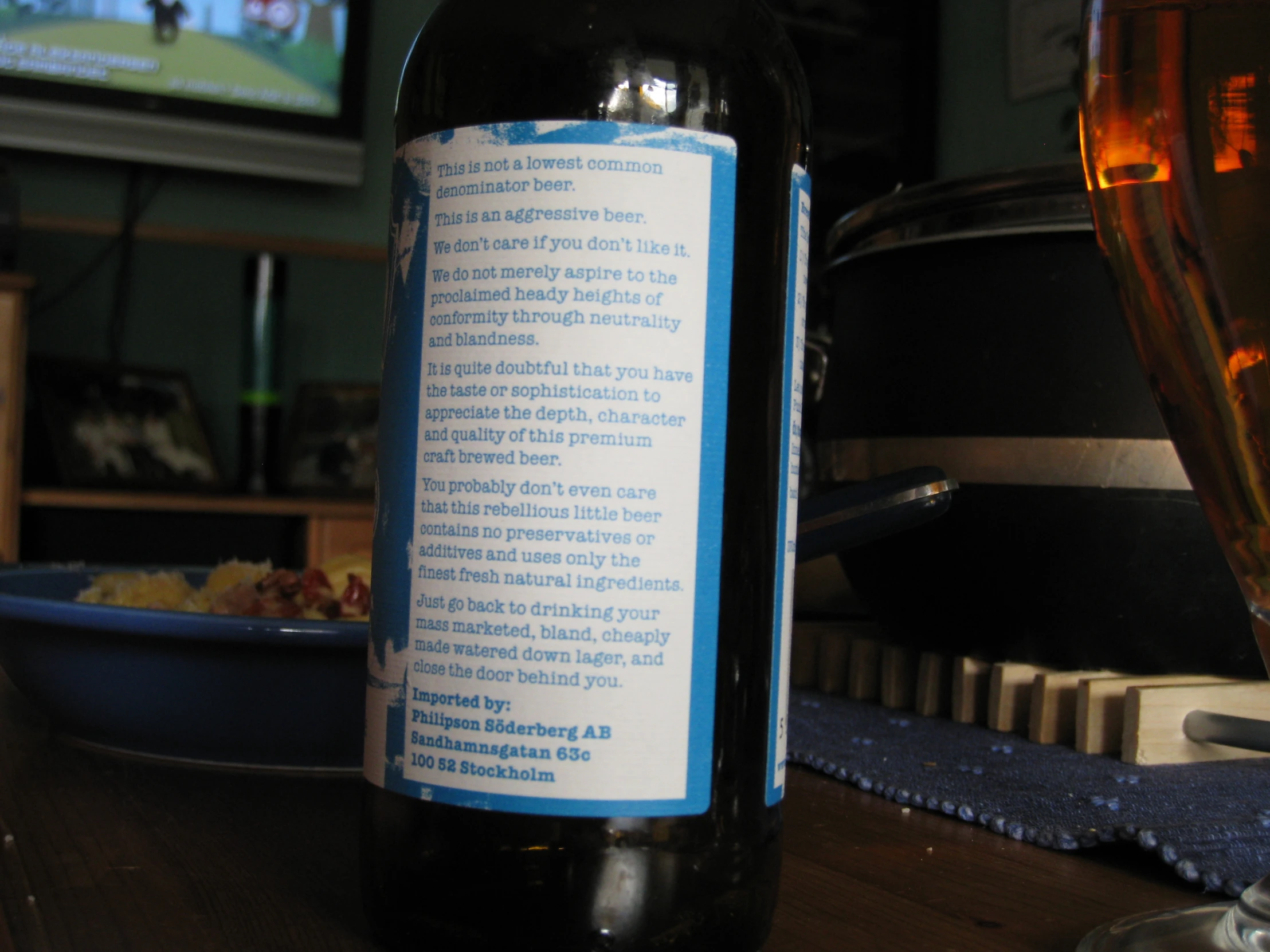 a bottle of beer on a table next to a bowl and bottle