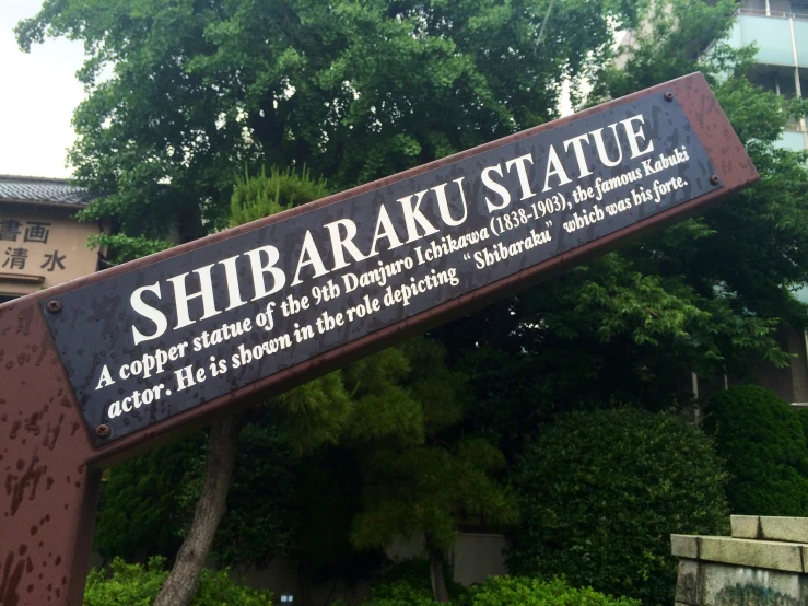 the street sign is near a tree in an asian village