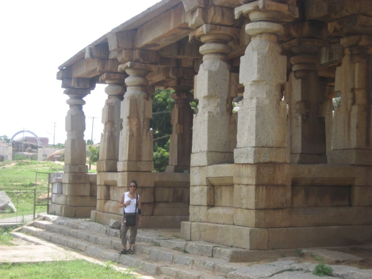 the young person standing by a line of ancient stone pillars