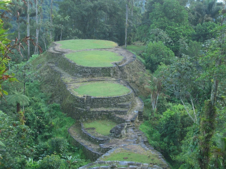 a stone structure built into a hillside surrounded by trees