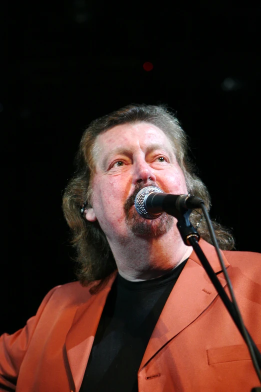 a man wearing a red suit and black shirt