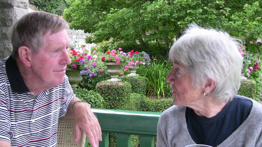 an elderly couple sitting next to each other on a bench