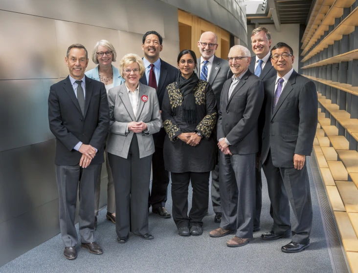 a group of business people stand smiling with one another