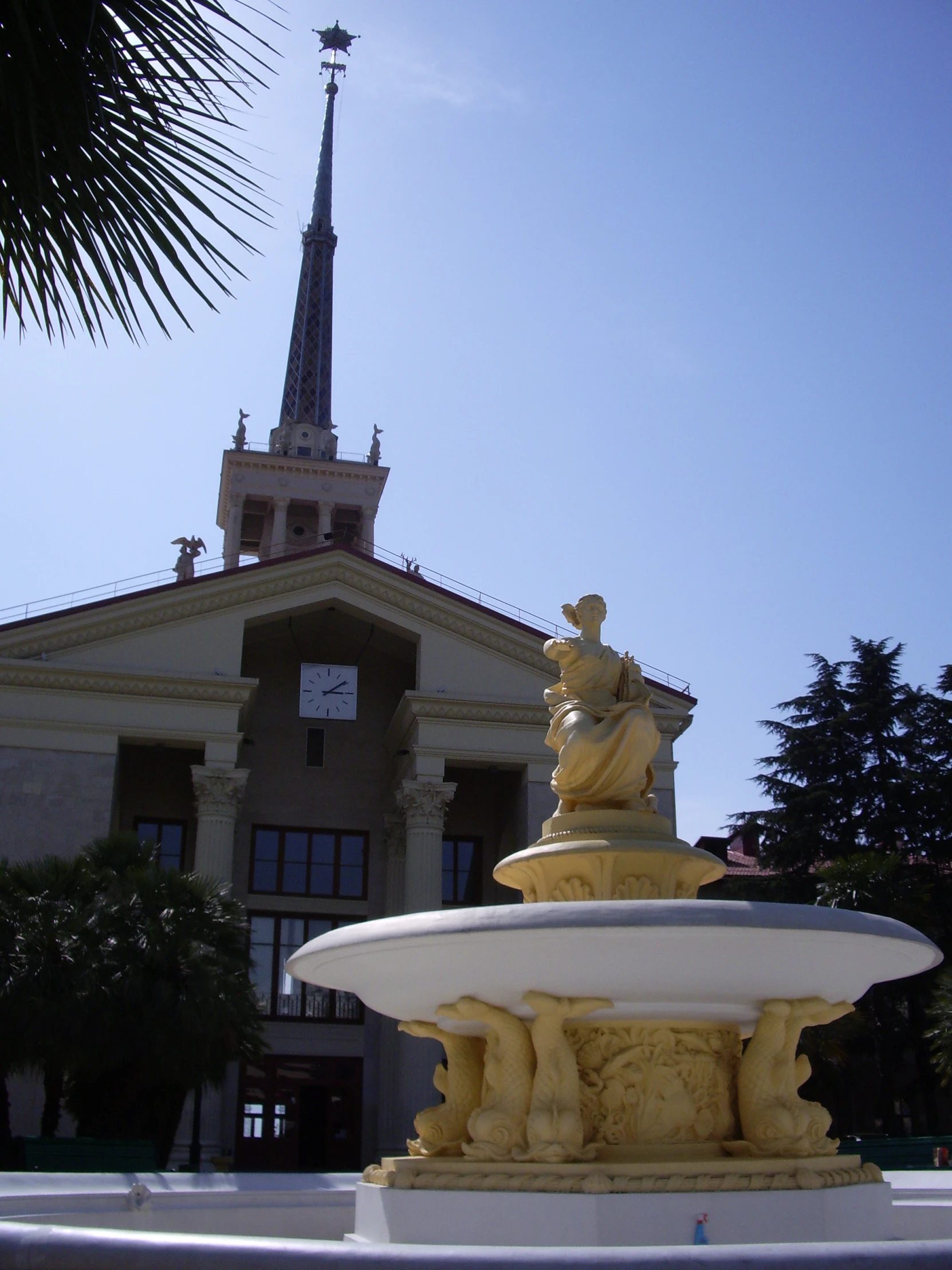 a statue sits outside of a tall building