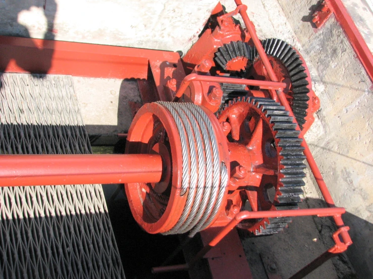 a red machinery is laying next to a white wall