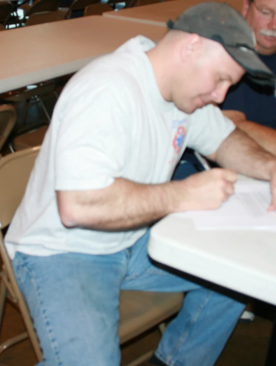 a man signing paperwork in front of his friend