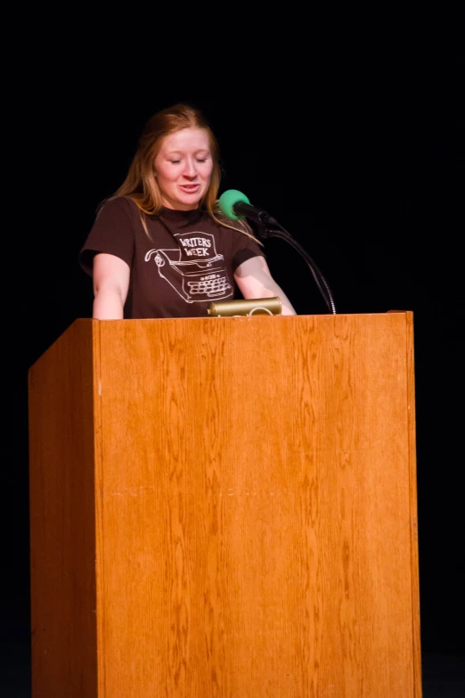 a woman sitting at a podium in front of a microphone