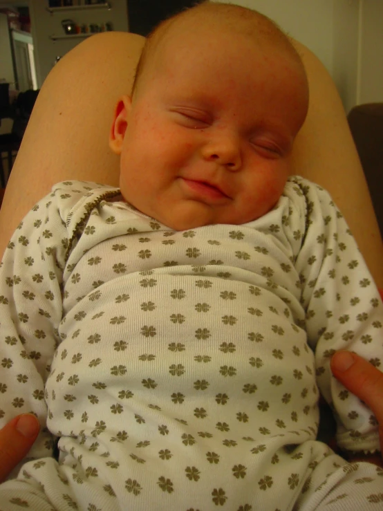 a newborn baby is laying down on someone's lap