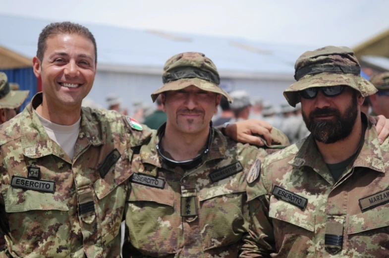three men are standing and posing in camouflage clothes