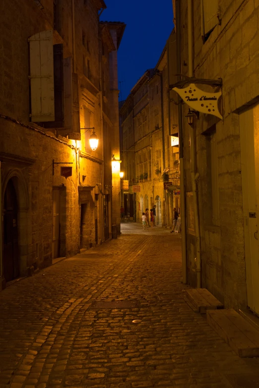 a street at night with stone streets and a cobblestone road