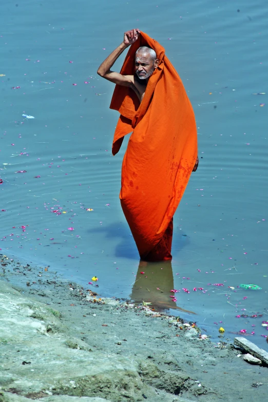 a man is walking in the water while wrapped up