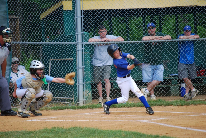 a boy hitting a baseball with a bat at a game