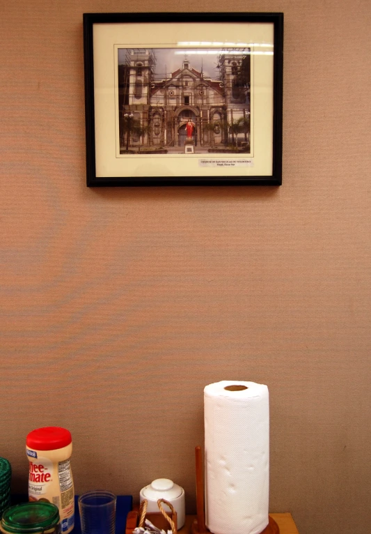 there is a picture hanging above the toilet