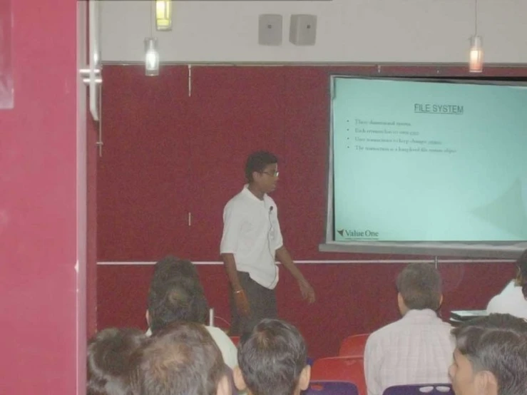 there is a man in the white shirt presenting a presentation to an audience