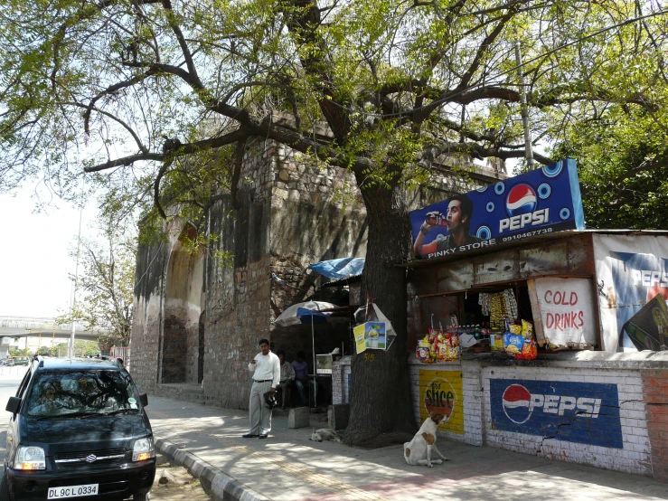 an outdoor restaurant with cars parked along side of it