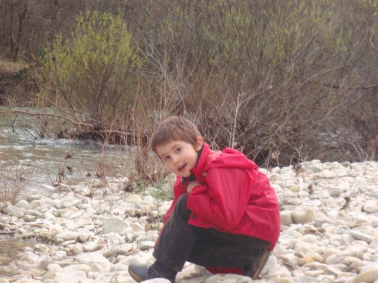 a  crouching on rocks next to the river