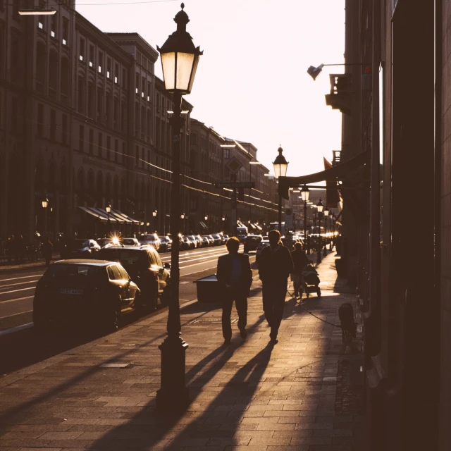 people walking down a street next to tall buildings