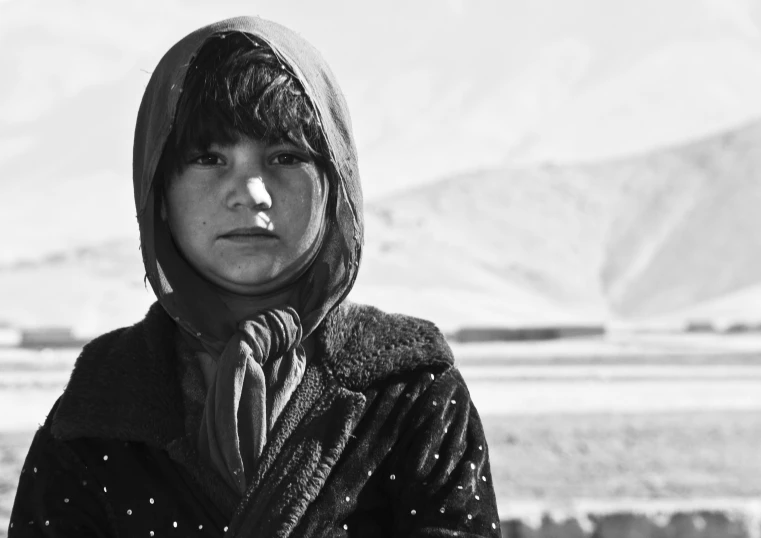 a woman with a scarf on is standing in the snow