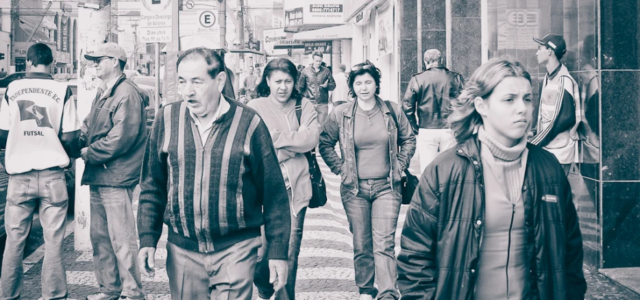 group of people walking on a sidewalk next to a building