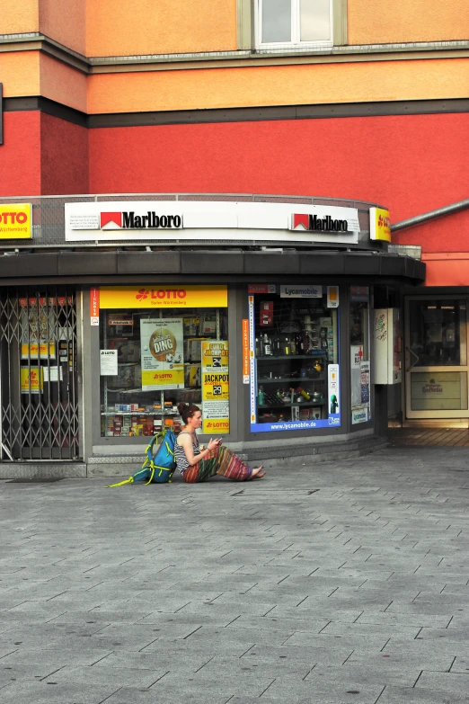 people are sitting in front of stores on a city street