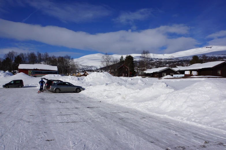 a couple of cars are parked on snow covered roads