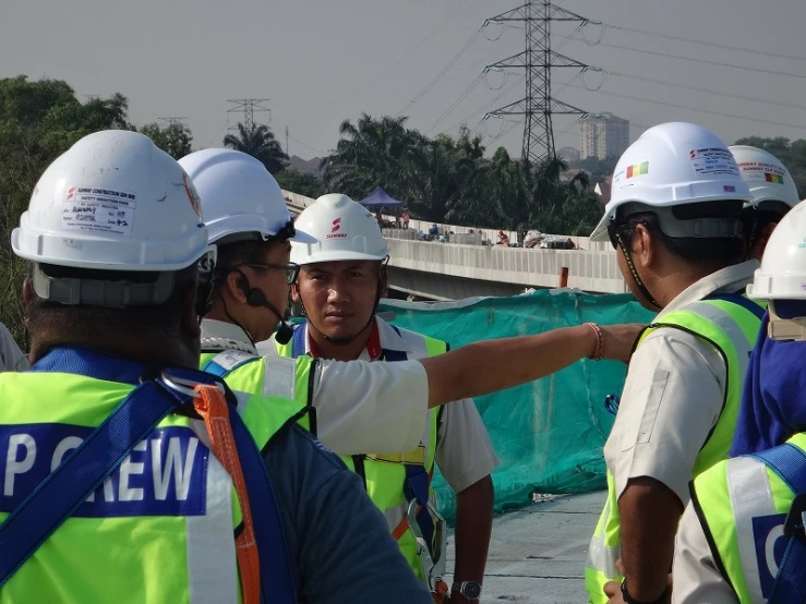 construction workers wearing safety vests talking to each other