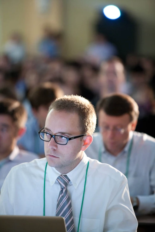 a man in tie and glasses working on laptop