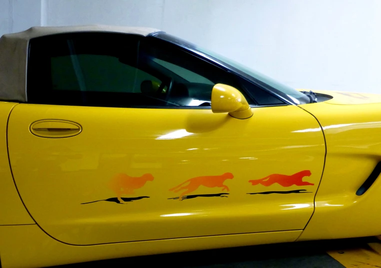 a yellow car with some red animals on it