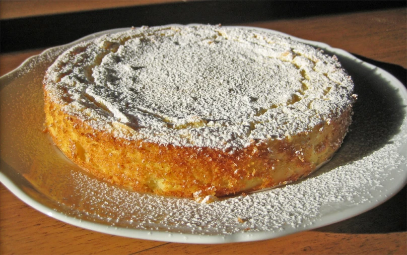 a powdered sugar - covered cake sits on a plate
