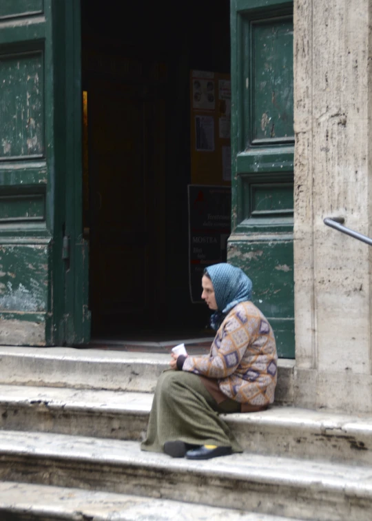 a woman sitting on the steps using her cell phone