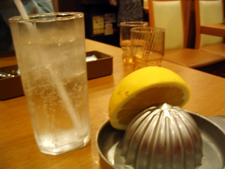 a pitcher of water sits next to an unidentifiable fruit slicer on the table