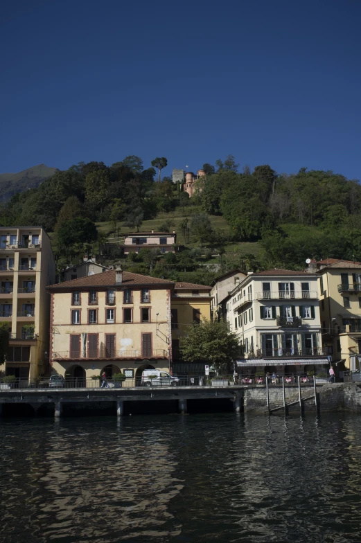 the waterfront with houses along it is lined up on a hill above water