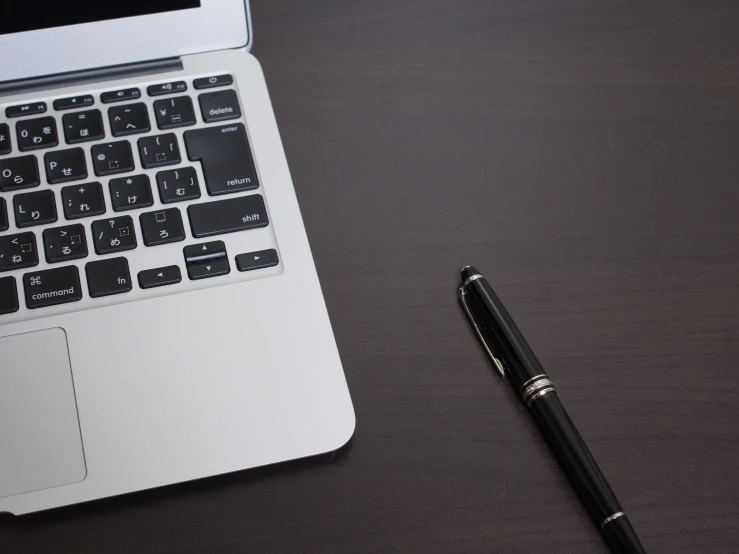 a white laptop computer sitting on top of a wooden table