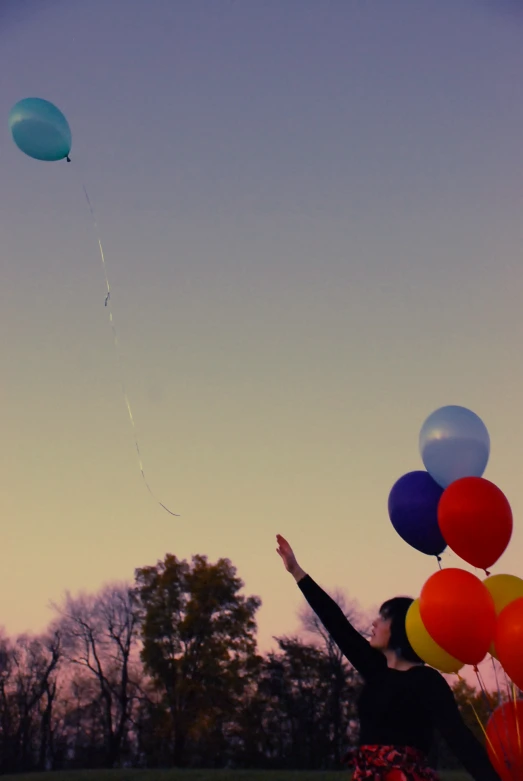 a woman flying two balloons while holding onto the strings